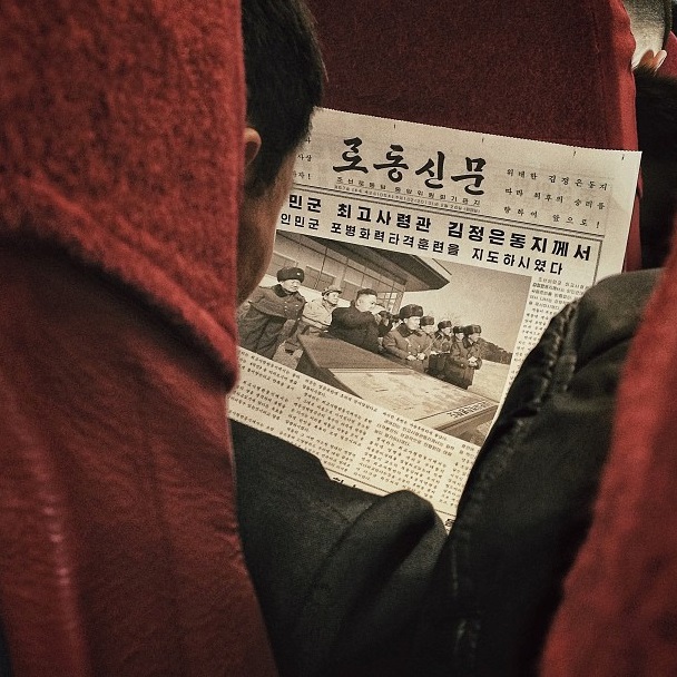A North Korean passenger aboard a North Korean Air Koryo flight from Pyongyang to Beijing reads a newspaper article about leader Kim Jong Un. Instagram image by David Guttenfelder