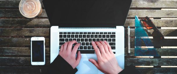 overhead shot of hands typing on a laptop