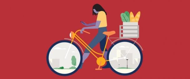 woman looking at phone while walking bike