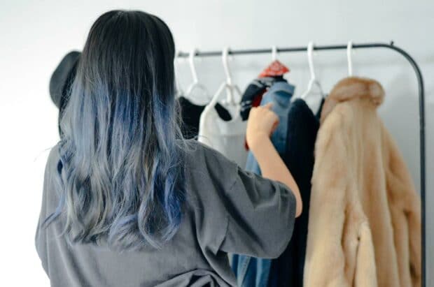 retail stylist arranging coats on hangers