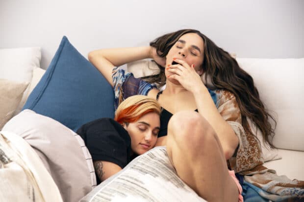 two non-binary models napping together in bed