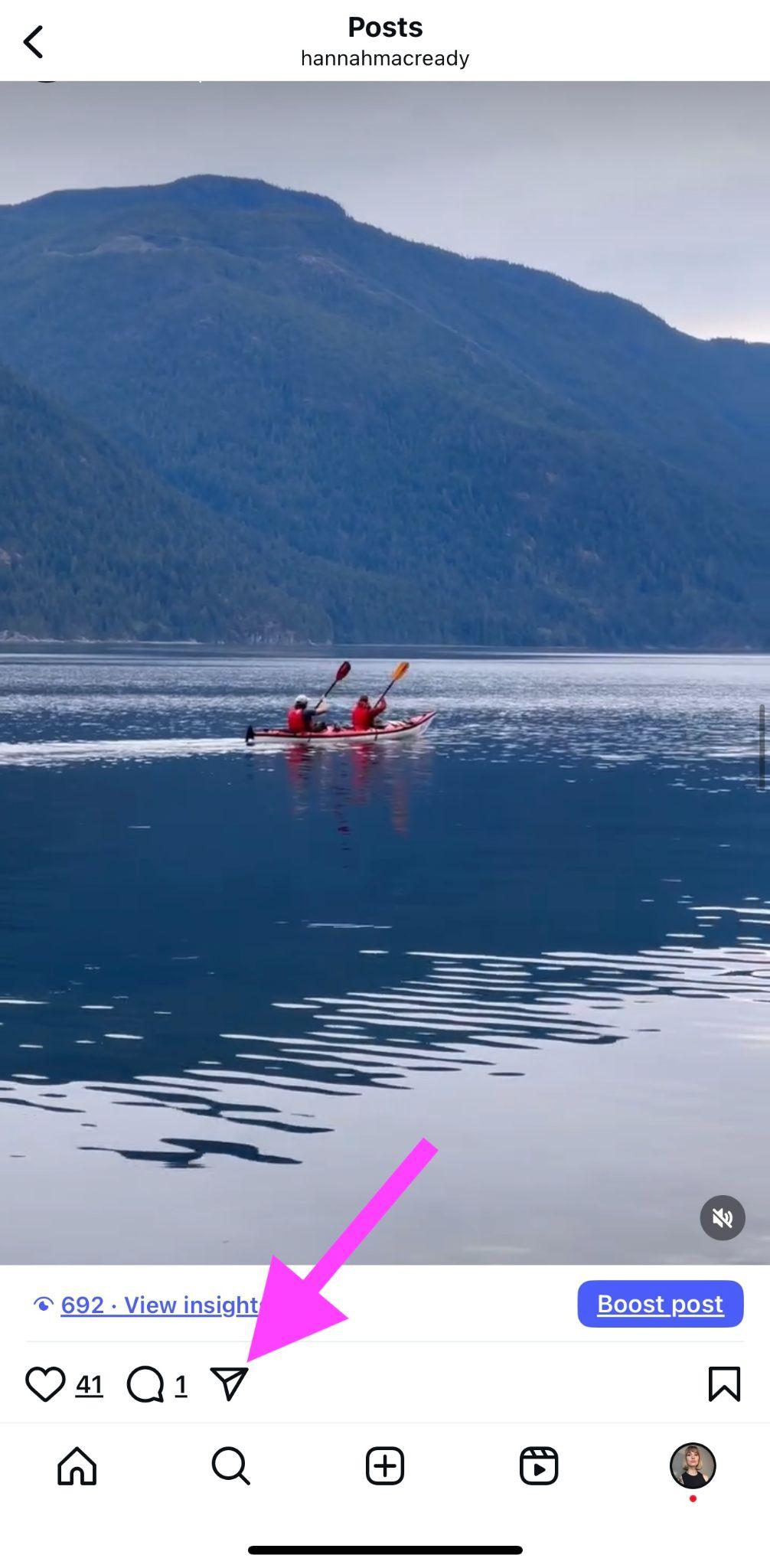 instagram reel with pink arrow pointing to the paper airplane icon in the bottom left of the video