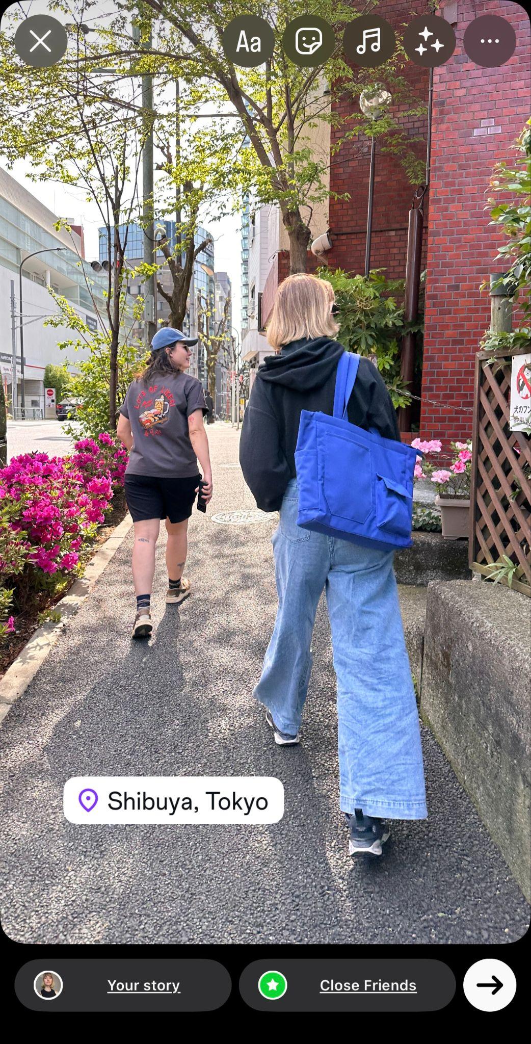 instagram story showing two women walking down a street in tokyo. a location tag reads Shibuya, Tokyo