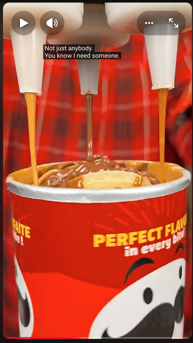 Screenshot of a video showing three streams of sauce being poured into a Pringles can. On-screen text reads: "Perfect flavor in every bite." Partially visible caption text reads: "Not just anybody. You know I need someone."